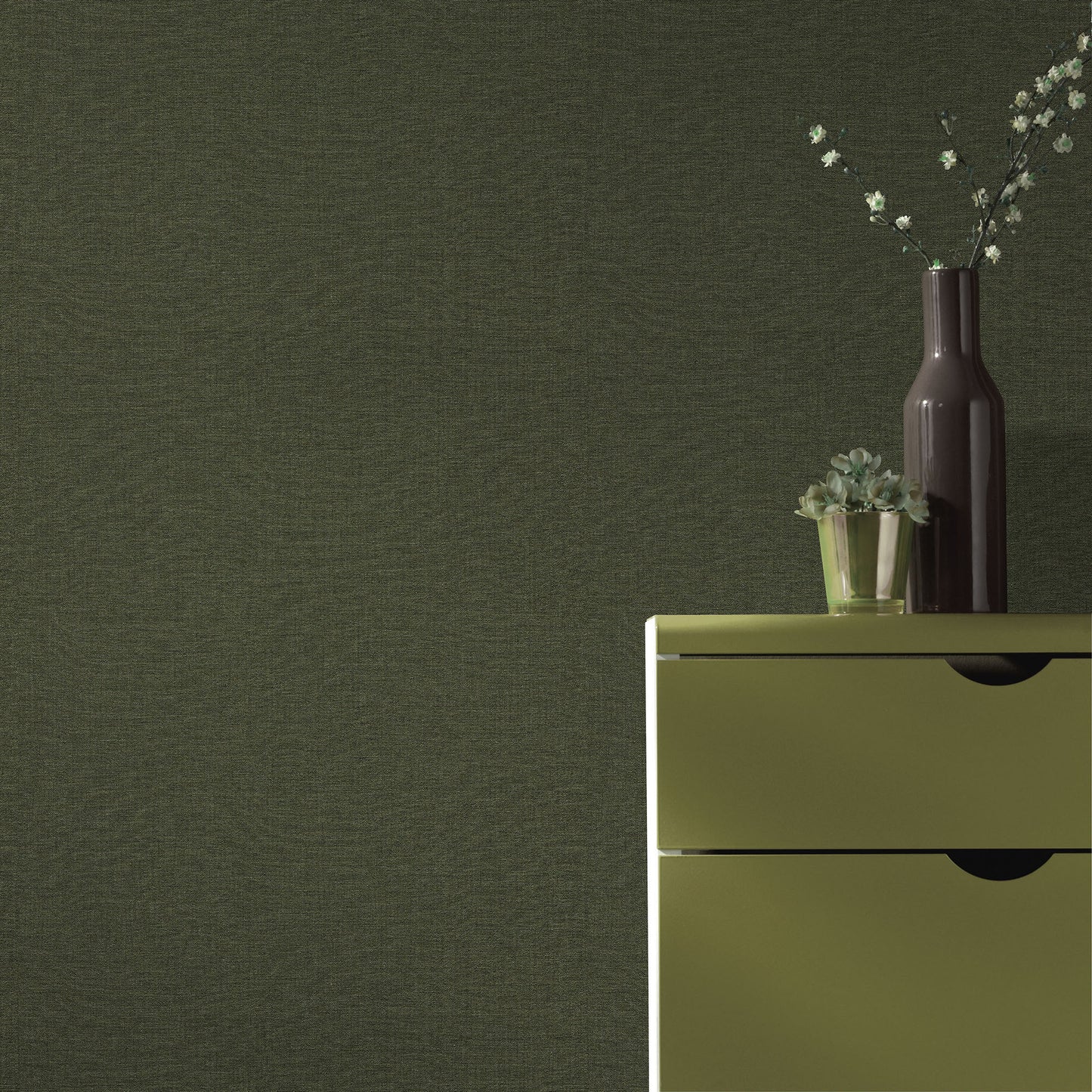 Olive-green wallpaper pattern on a wall, with a tall dark vase and a small succulent on a surface.