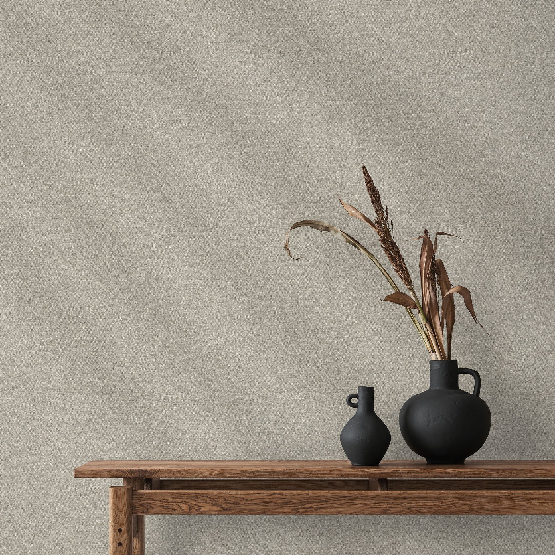 Taupe linen-textured wallpaper with a subtle traditional pattern on the wall.