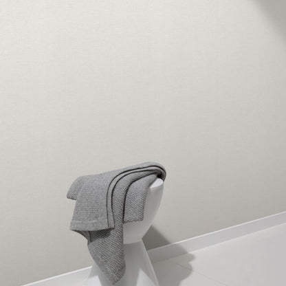 Light grey linen-textured wallpaper on a white wall in a minimal modern setting.