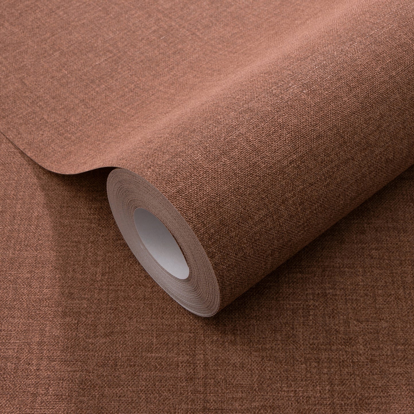Warm red wallpaper roll with linen-like texture and traditional pattern.