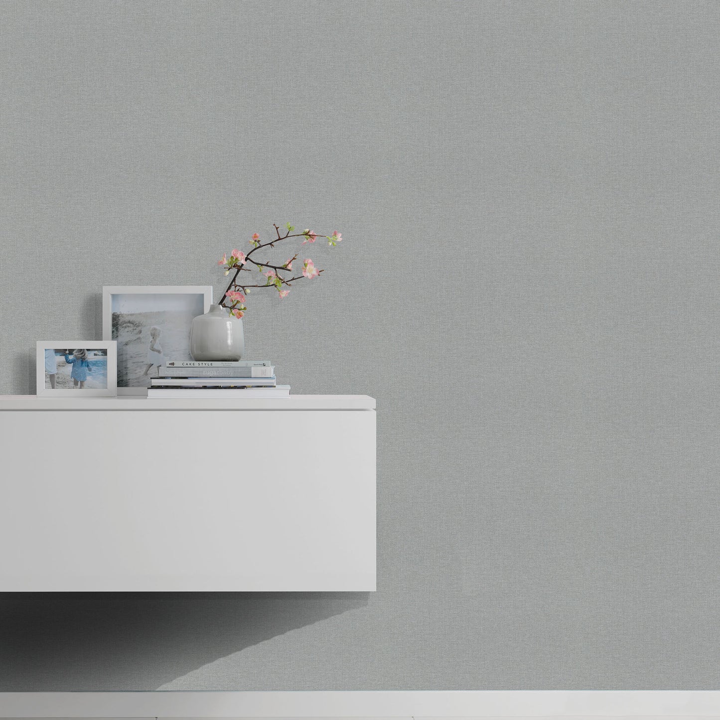 Gray wallpaper on wall with subtle linen texture.