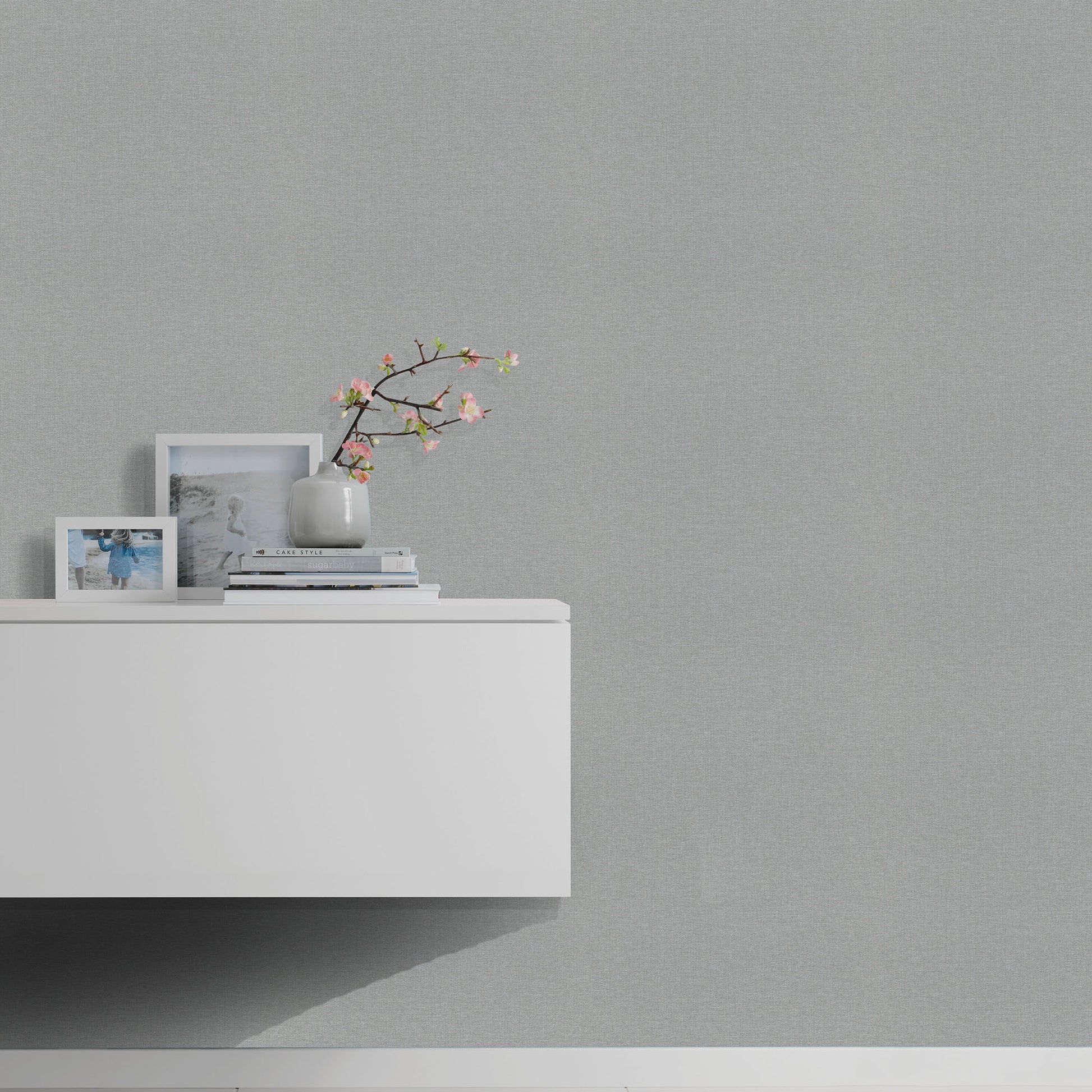 Gray wallpaper on wall with subtle linen texture.