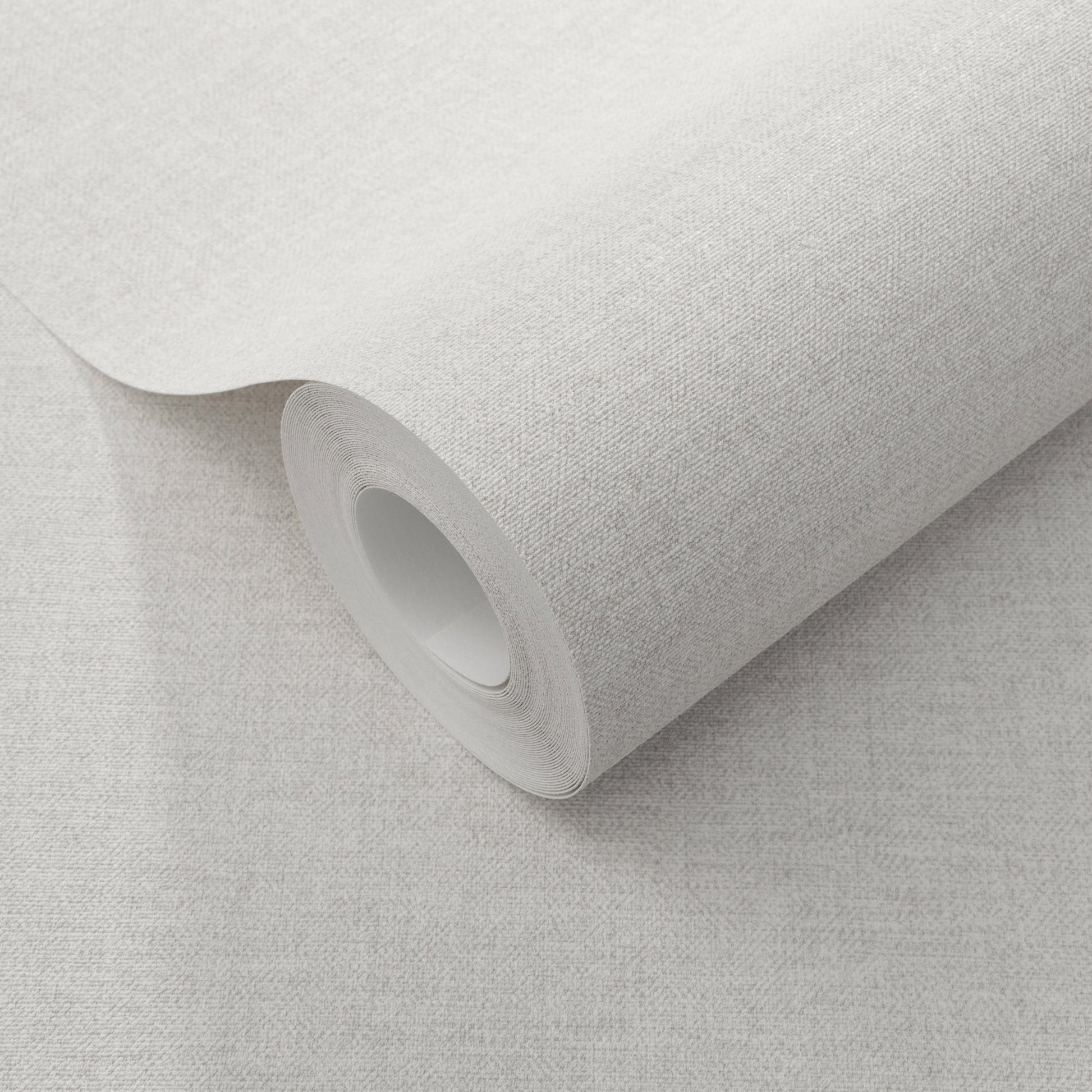 Cream linen-textured wallpaper roll with a cardboard core, partially unrolled.