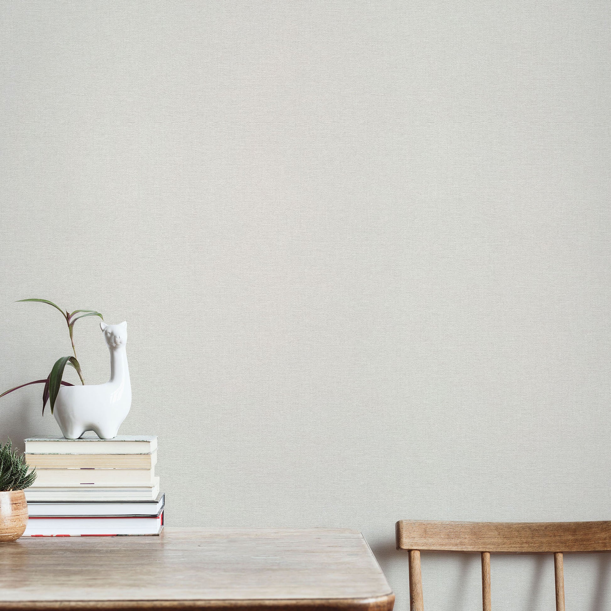 Cream wallpaper with a linen texture and traditional pattern.