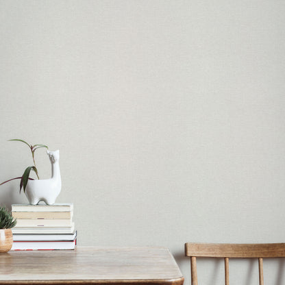 Cream wallpaper with a linen texture and traditional pattern.