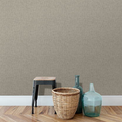 Beige tan linen-weave textured wallpaper on a wall in a neutral room with a wooden floor.