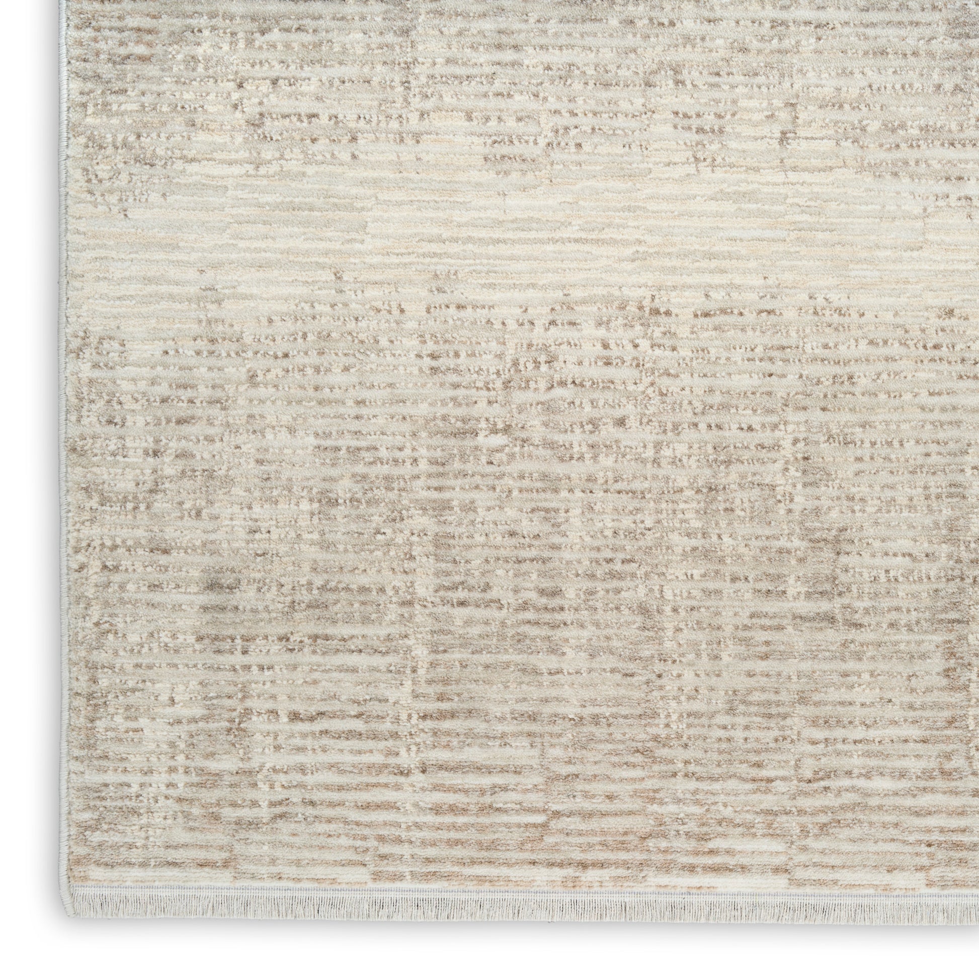 Neutral beige distressed area rug with abstract pattern and light fringe along the edge.