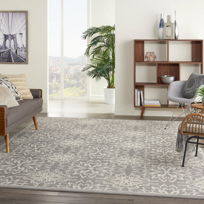Modern living room with a gray floral-patterned rug, mid-century sofa, wooden shelves, and a potted palm.