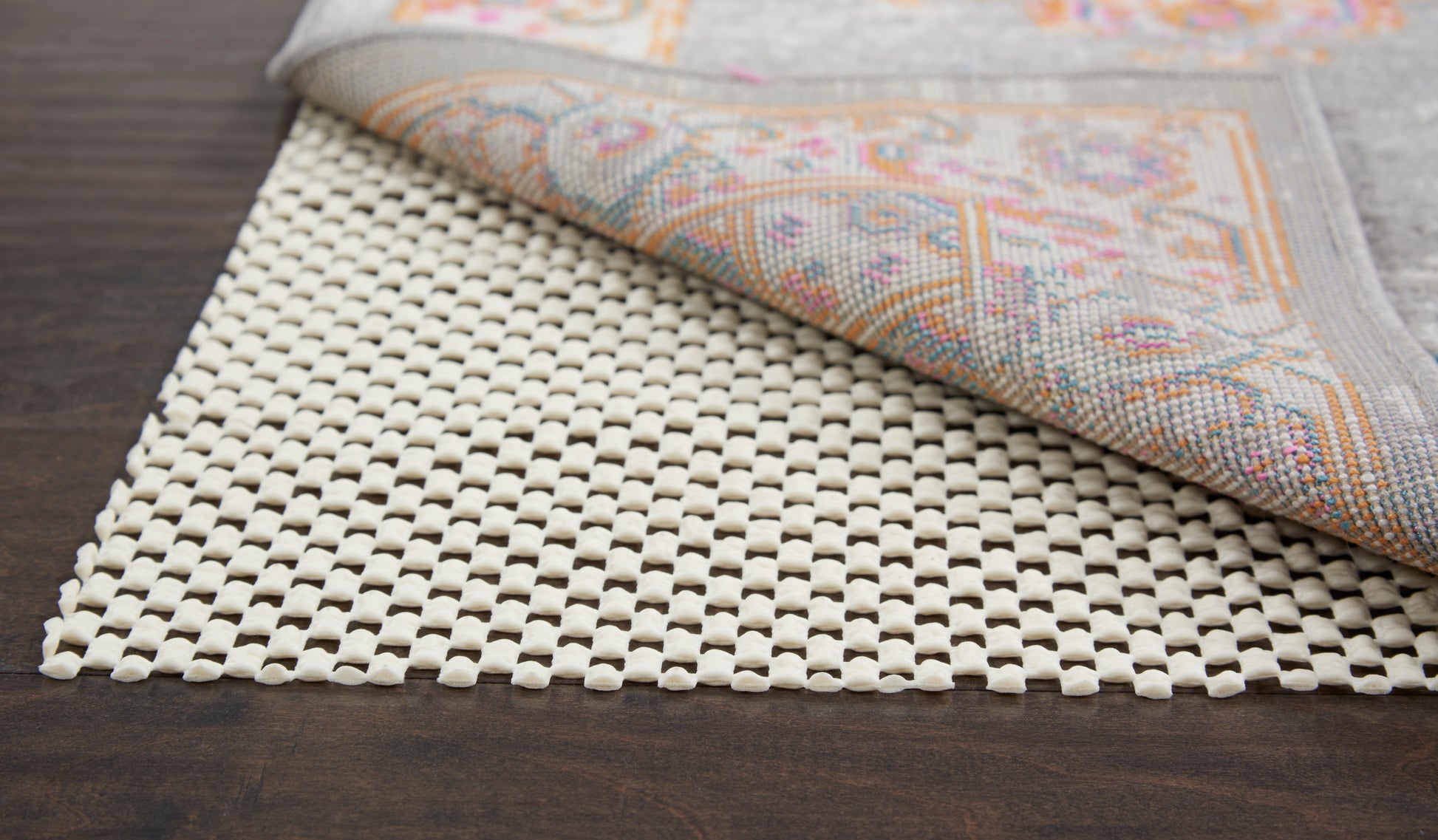 Beige woven lattice rug on dark wood floor.