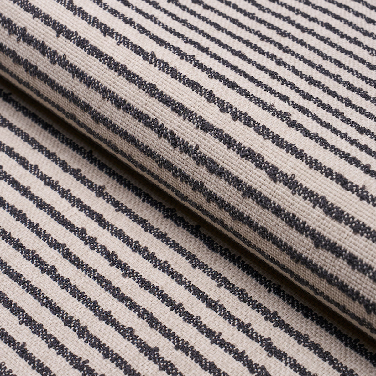 Beige woven fabric with narrow navy stripes, rolled textile sample.