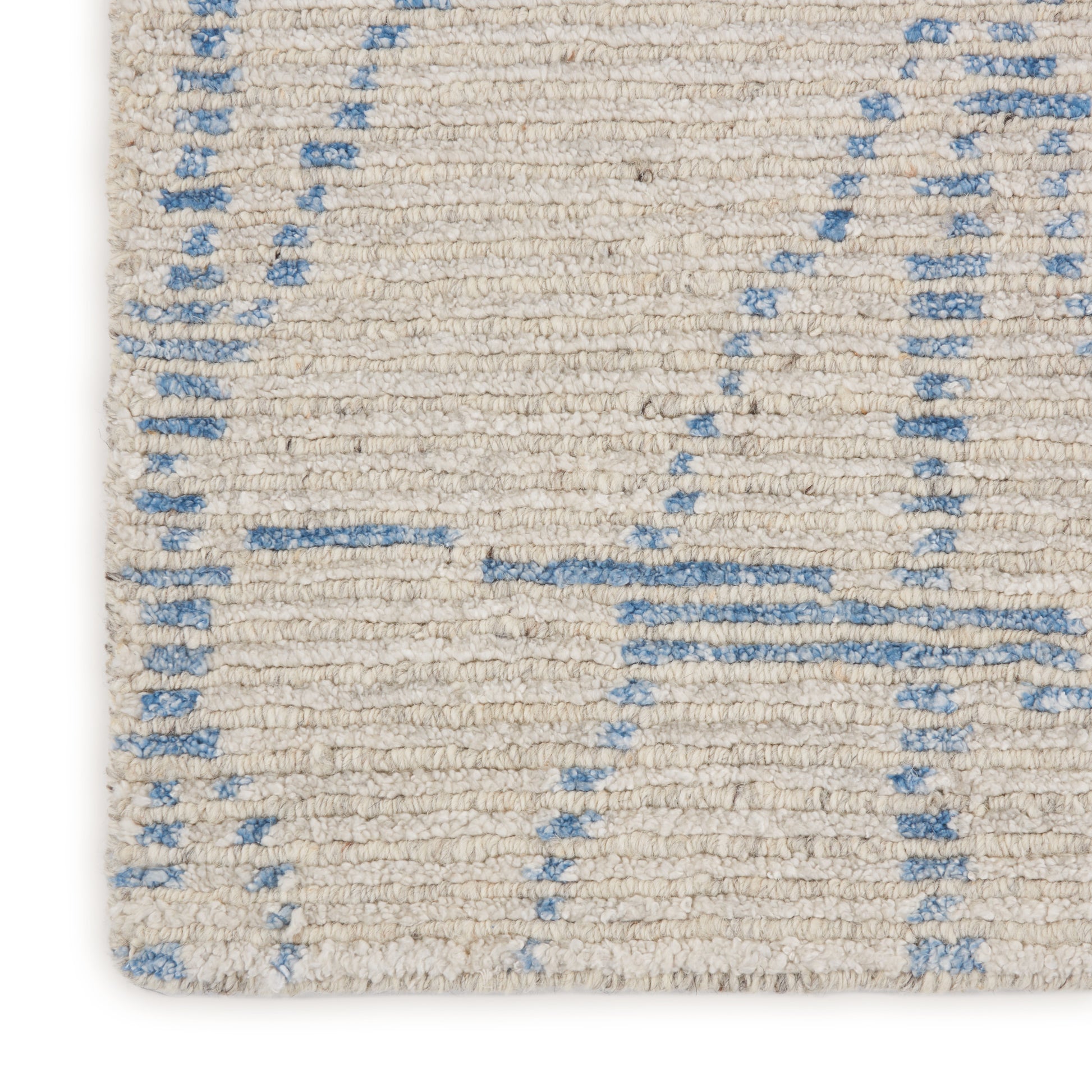 Cream woven rug with pale blue geometric lines; soft textured pile.