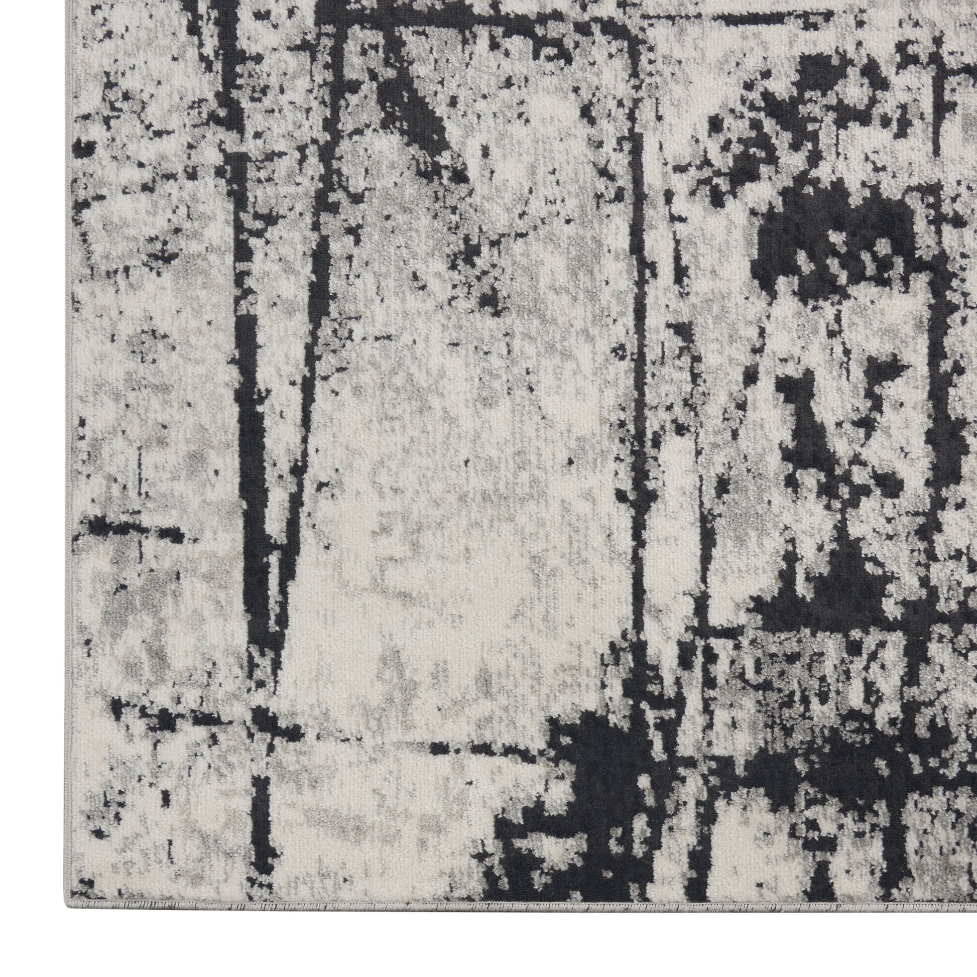 Gray and charcoal distressed area rug with abstract black pattern in neutral tones, soft pile.