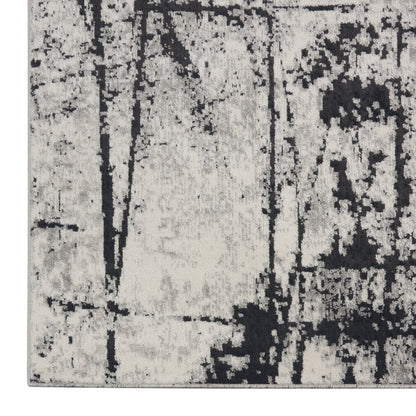 Gray and charcoal distressed area rug with abstract black pattern in neutral tones, soft pile.