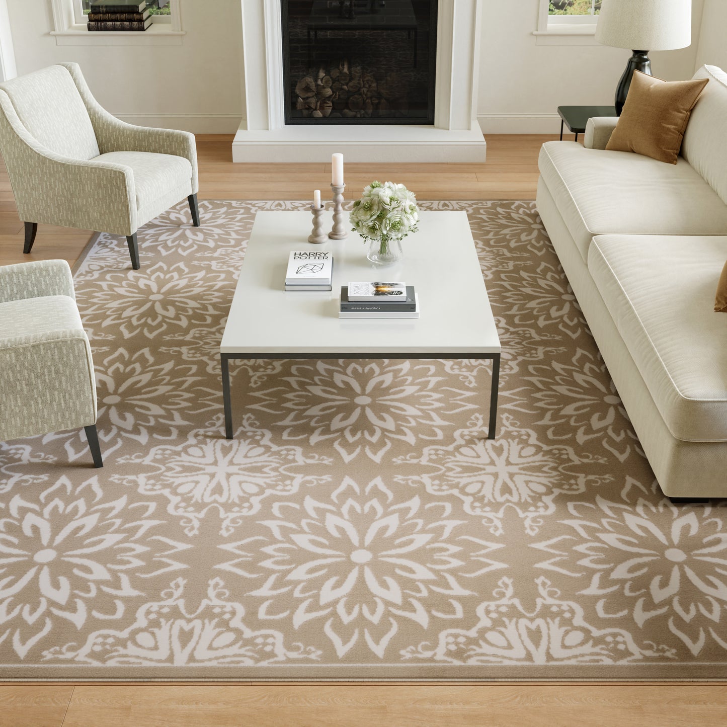 Living room with beige floral area rug, white coffee table, cream sofa and chairs, fireplace.