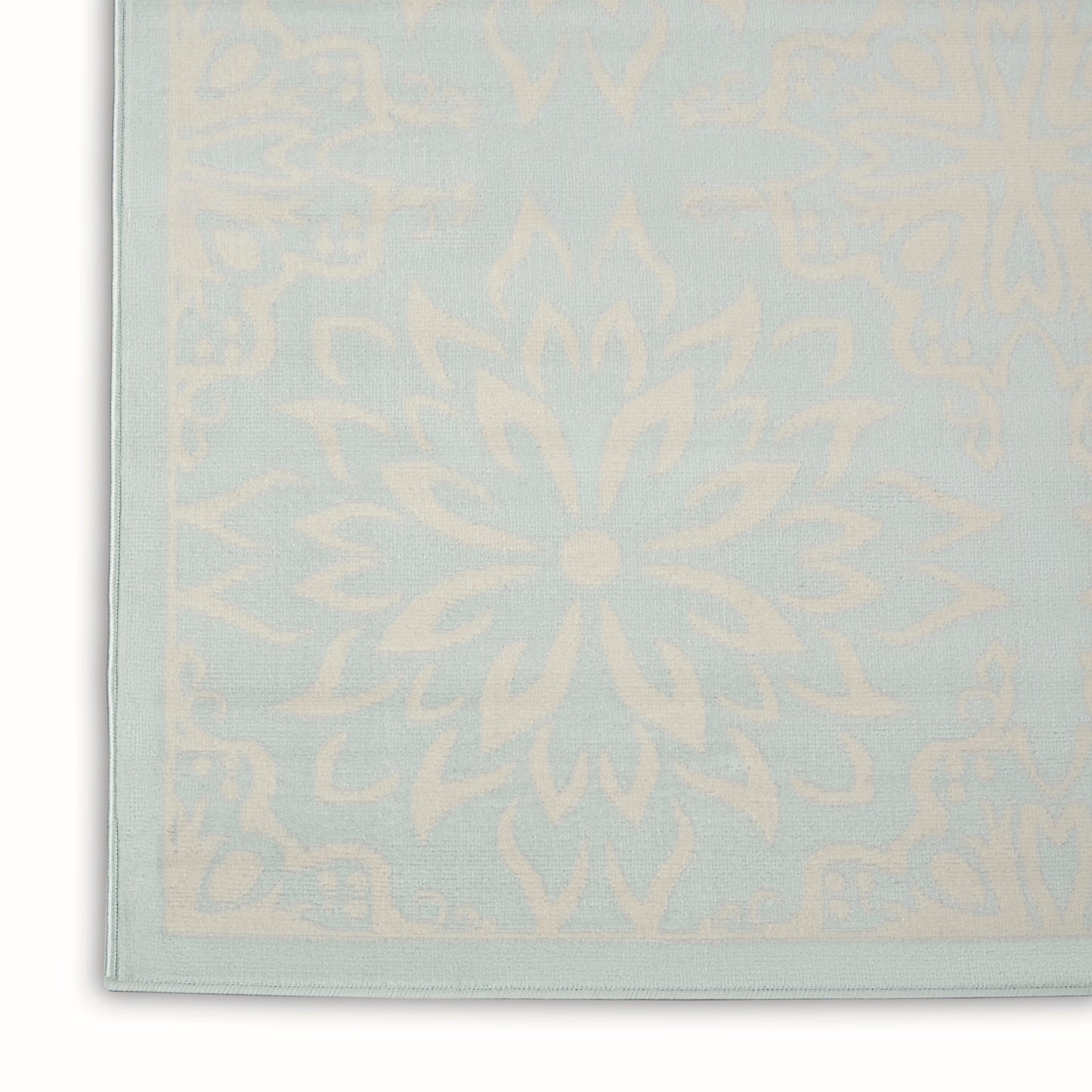 Pastel blue rug with cream mandala pattern and pale border.