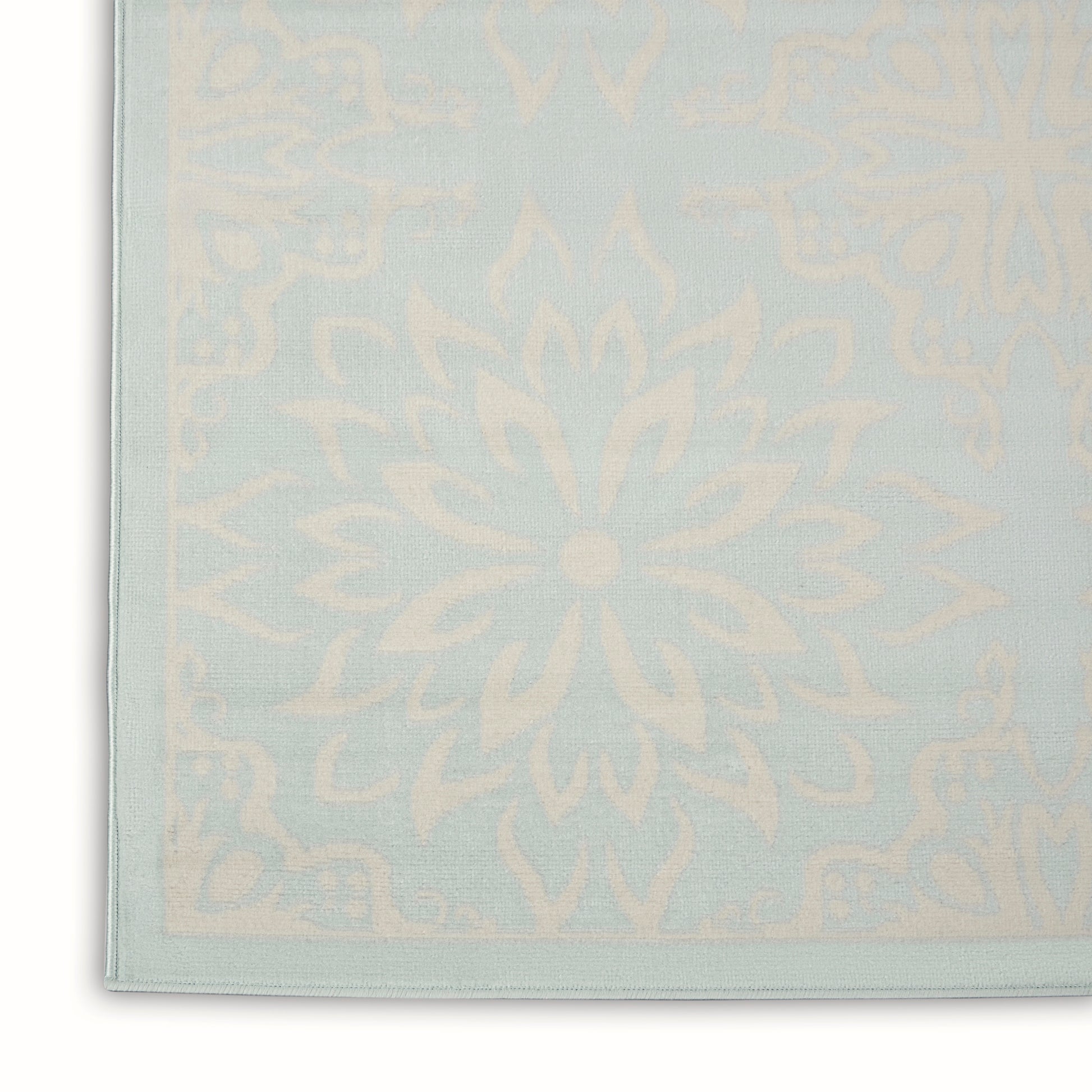 Pastel blue rug with cream mandala pattern and pale border.