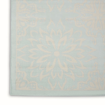 Pastel blue rug with cream mandala pattern and pale border.