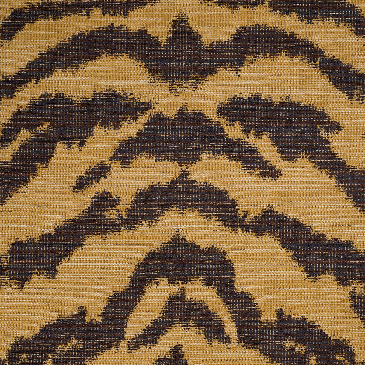 Gold tan woven rug with dark brown chevron and diamond geometric motifs in a rustic boho style.