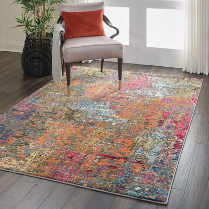 Colorful abstract rug over dark wood floor under a beige upholstered chair with an orange textured pillow.