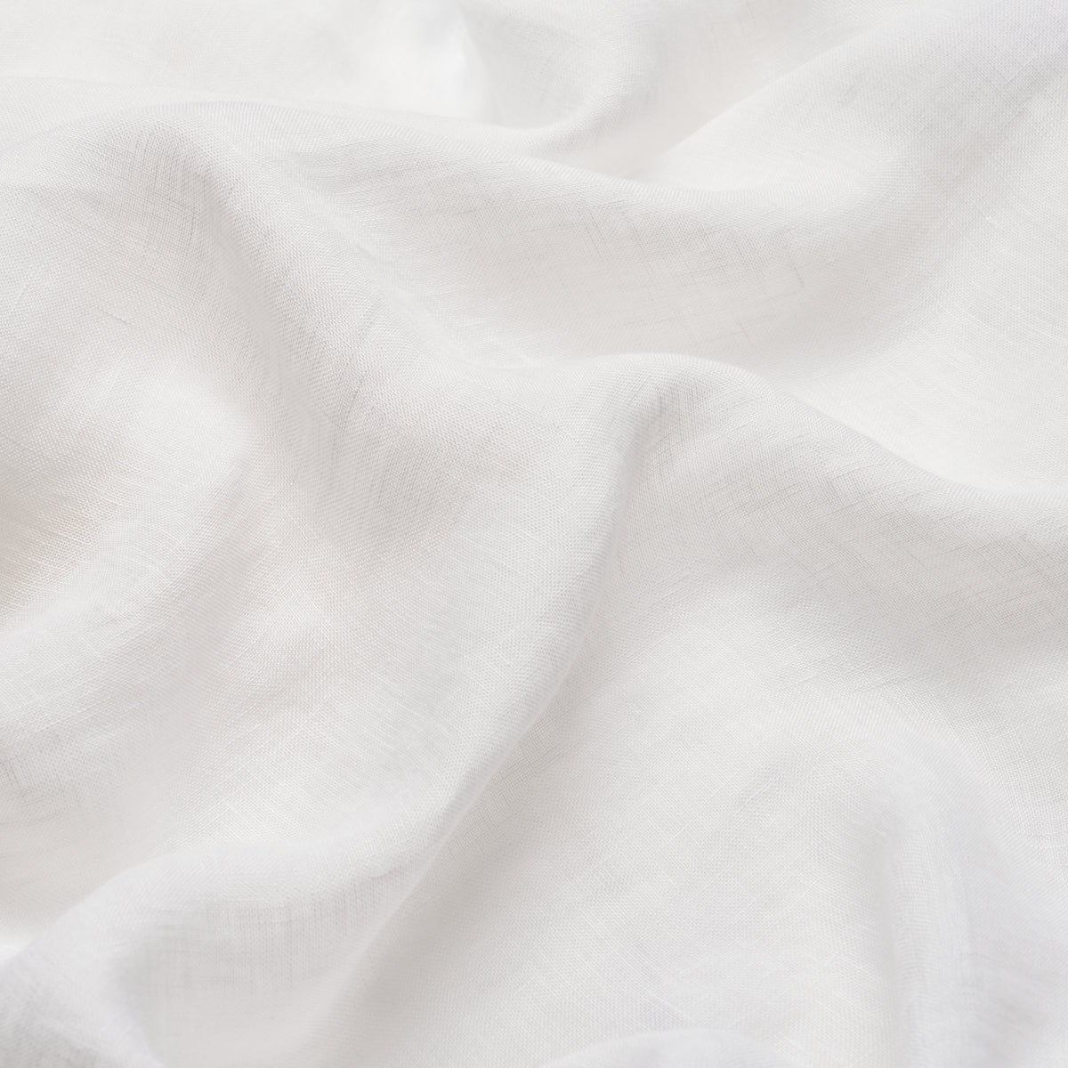 White fabric with soft folds and subtle woven texture, versatile for linens or clothing.