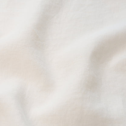 Cream linen fabric with soft drapes and subtle woven texture, natural off-white color.