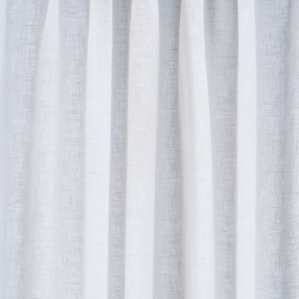 Light gray linen curtain panels with textured fabric and vertical pleats.