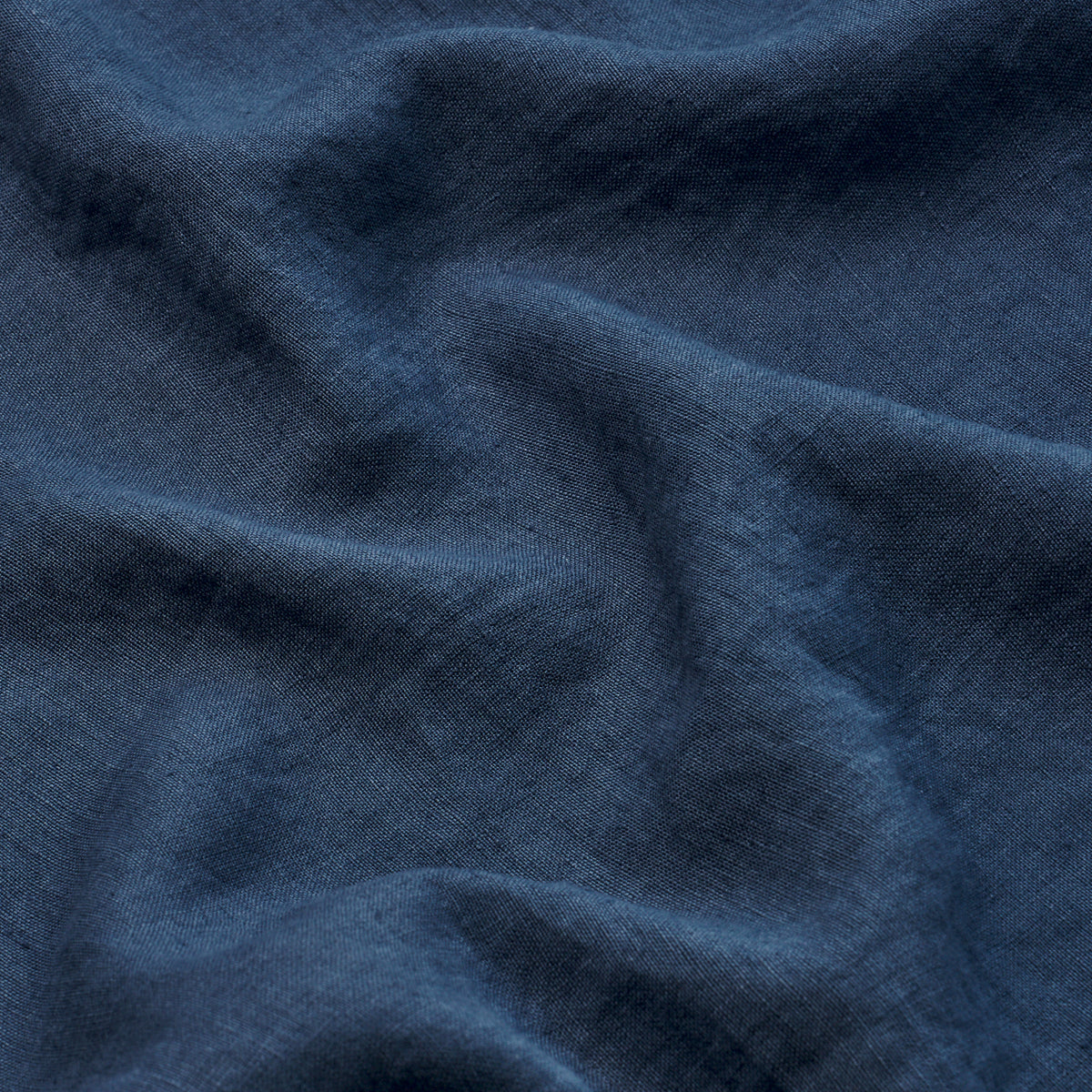 Dark navy blue woven fabric with soft drape and subtle texture, folds creating gentle ridges.