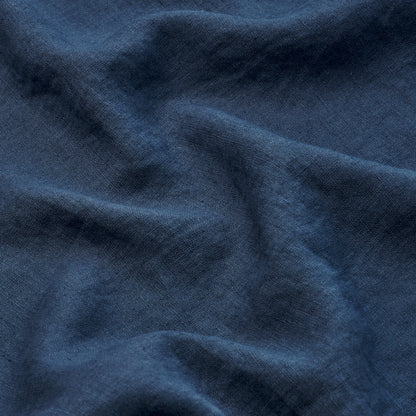 Dark navy blue woven fabric with soft drape and subtle texture, folds creating gentle ridges.