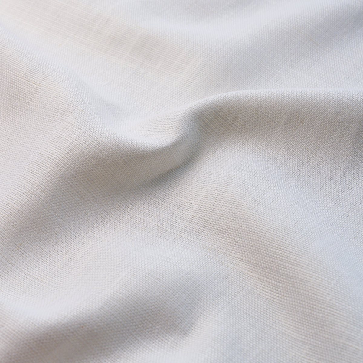 Cream-white woven fabric with fine texture and soft drape, ideal for garments or light upholstery.