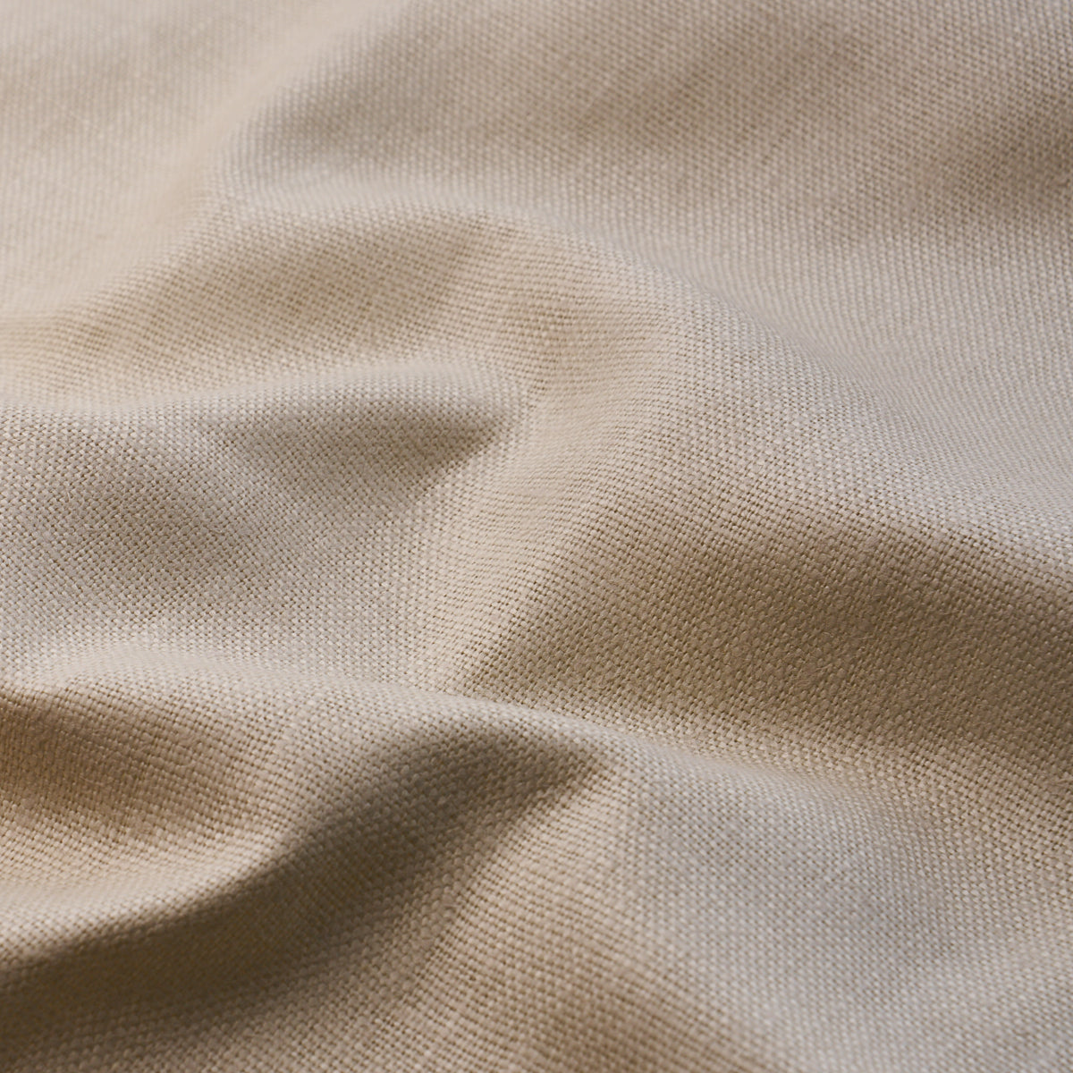 Beige woven fabric with visible texture and soft folds, linen-like drape.