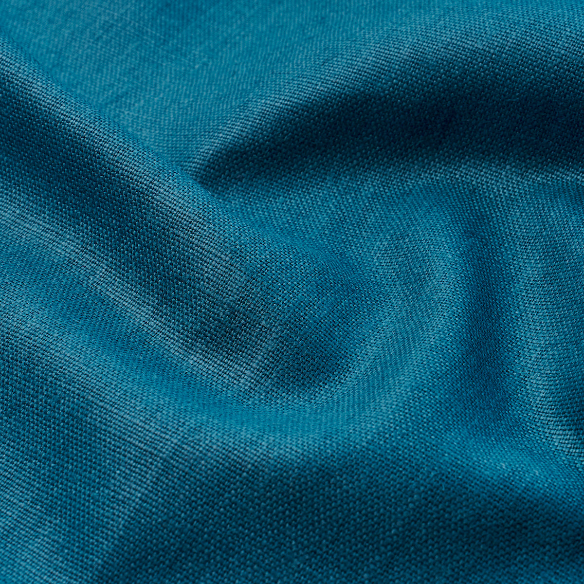 Teal-blue woven fabric close-up with soft folds and visible texture.