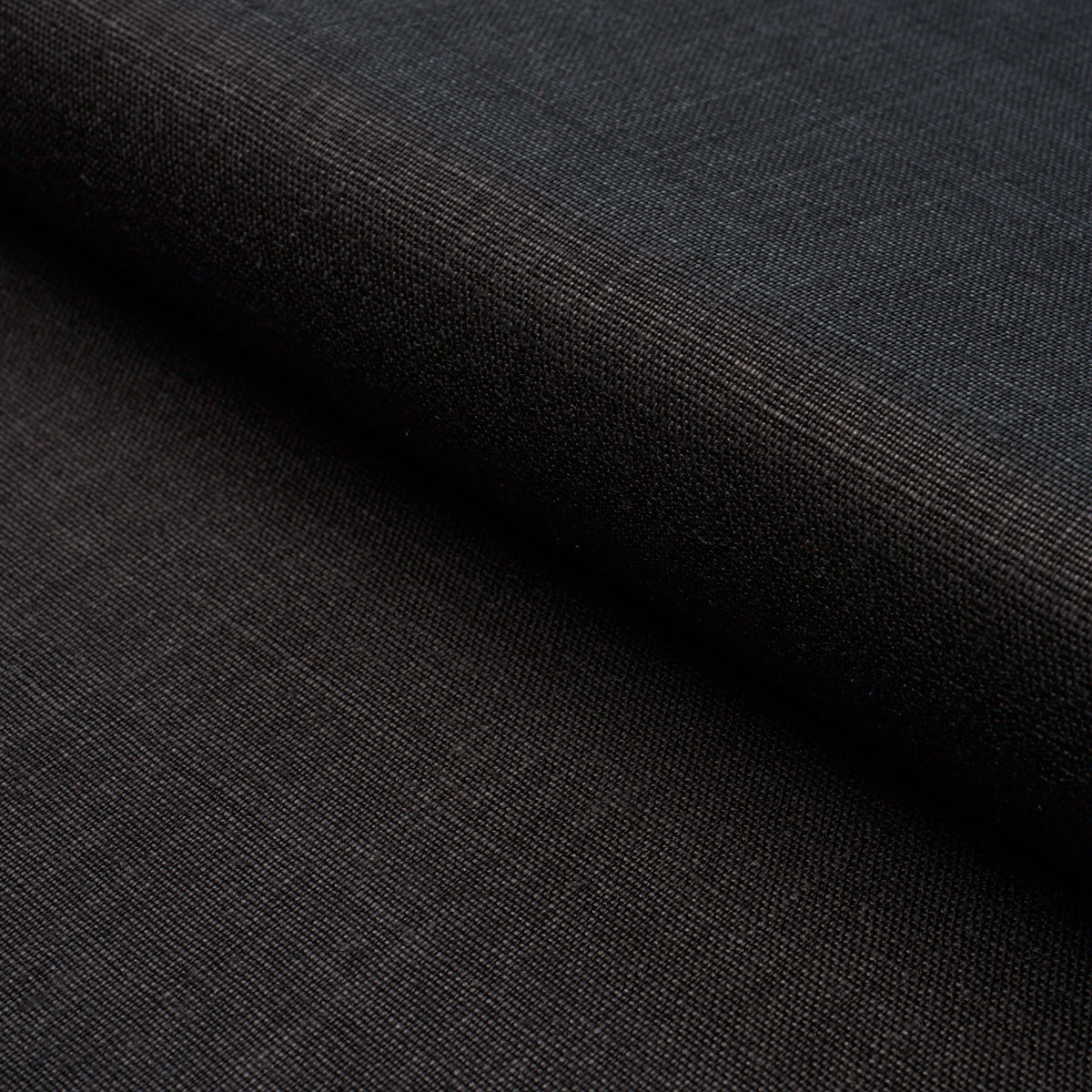 Dark charcoal woven fabric, fine texture with visible grain, folded edge, suitable for garments or upholstery.