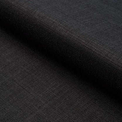 Dark charcoal woven fabric, fine texture with visible grain, folded edge, suitable for garments or upholstery.