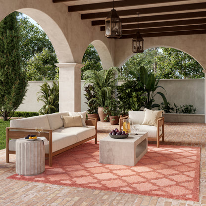 Beige rug with coral accents in a Mediterranean courtyard setting.