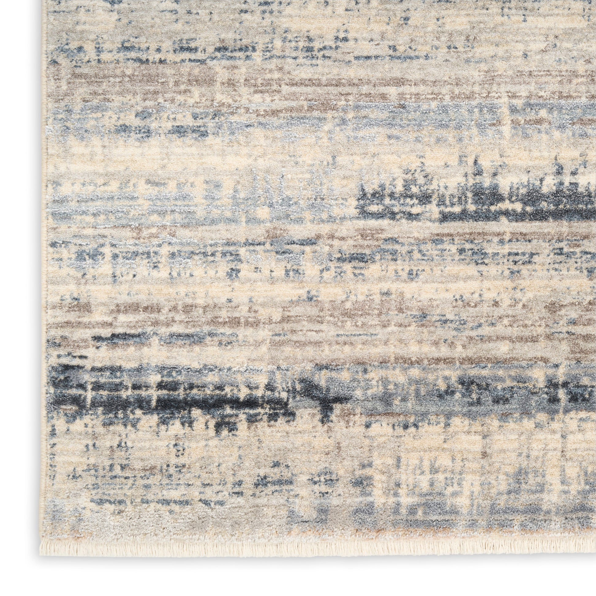 Abstract beige and blue area rug with muted brushstroke pattern and fringed edge.