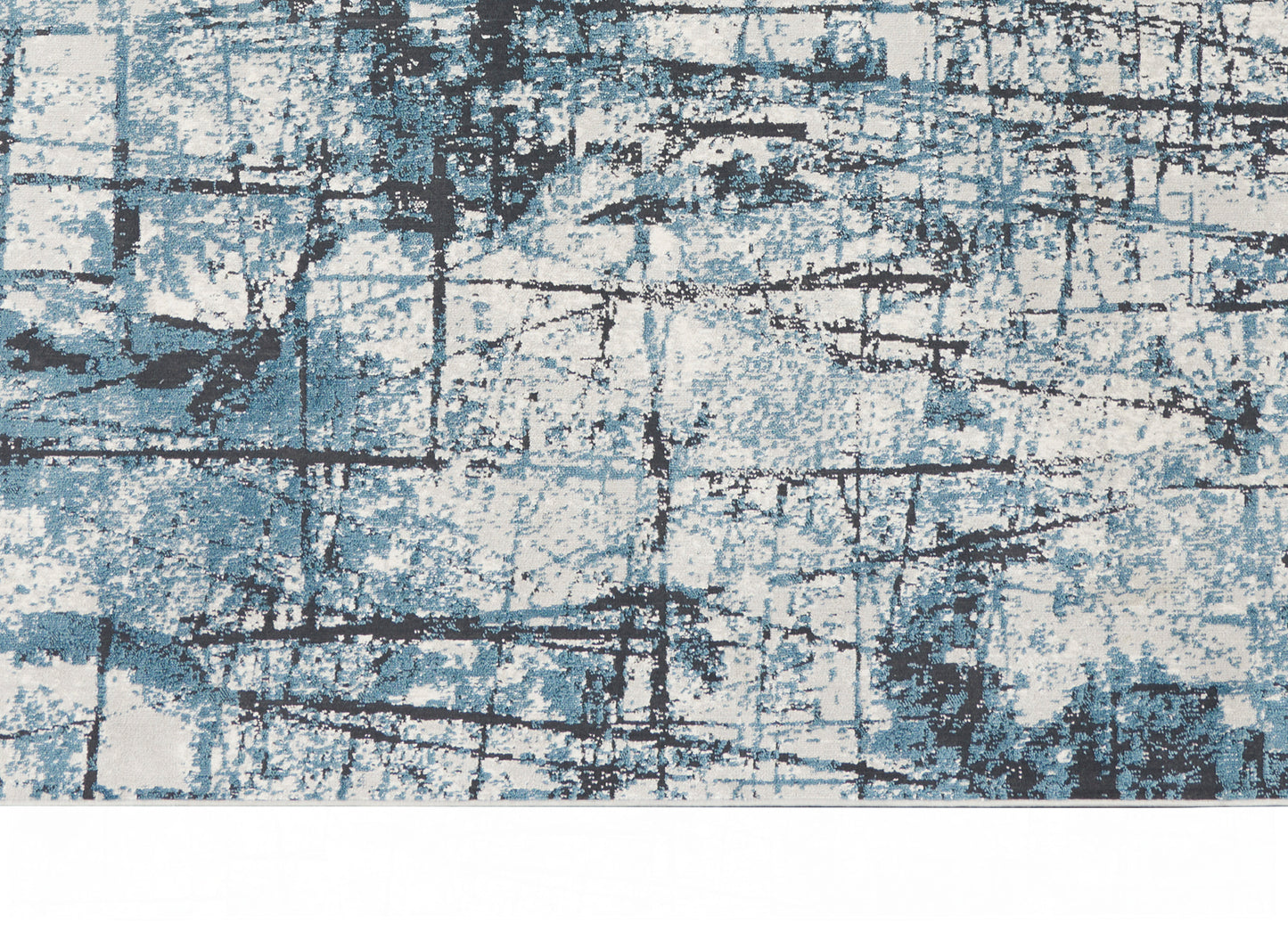 Abstract blue and white rug with distressed grid lines and charcoal accents for modern living spaces.