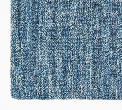 Blue textured shag rug with variegated light and dark blue fibers; soft loop-pile for indoor decor.