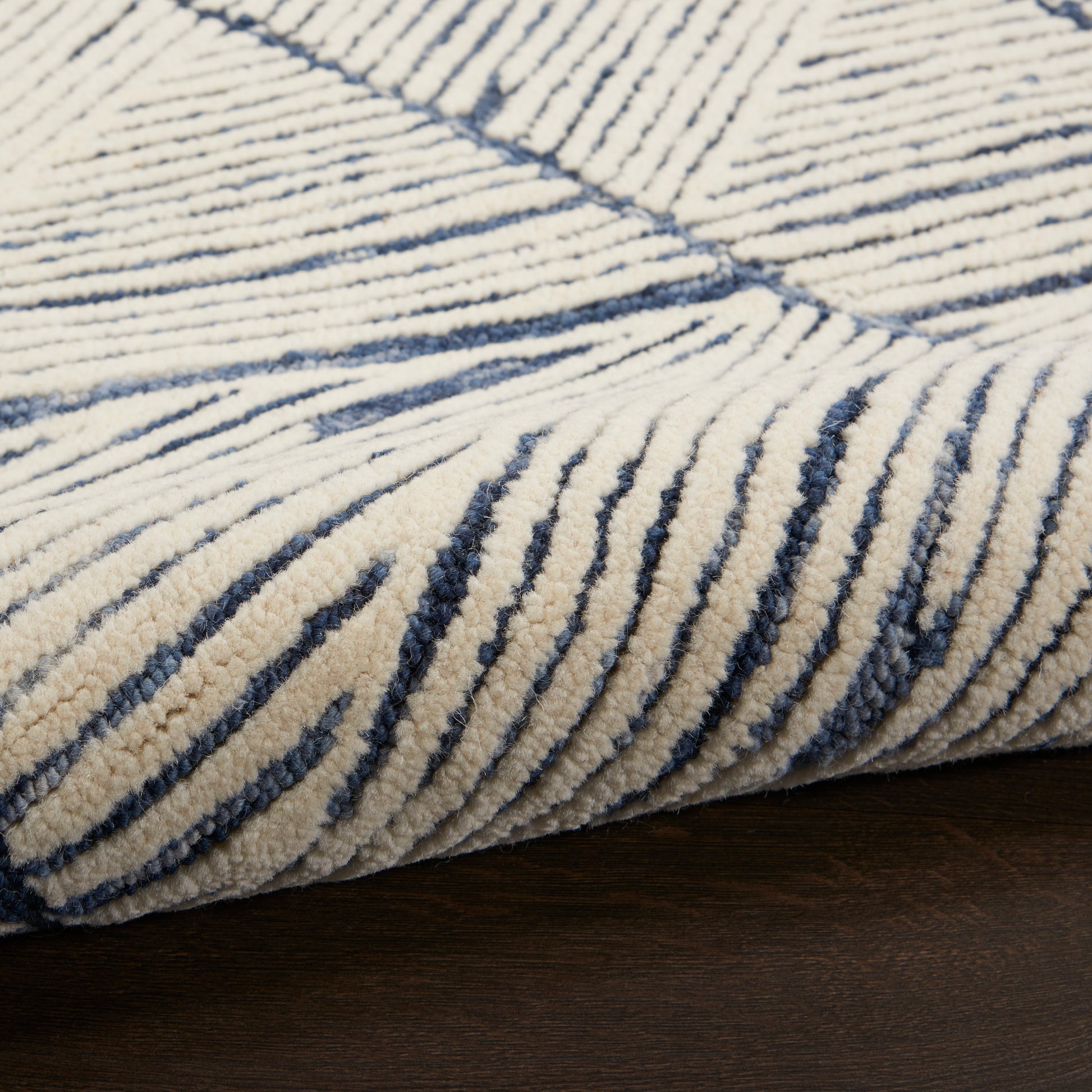 Cream shag rug with navy irregular linear stripes, plush pile on dark wood floor