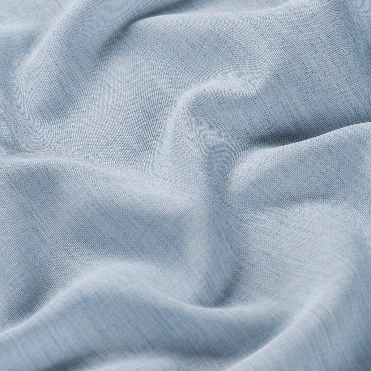 Light blue textured woven fabric with soft folds and visible fibers, ideal for shirts or bedding.