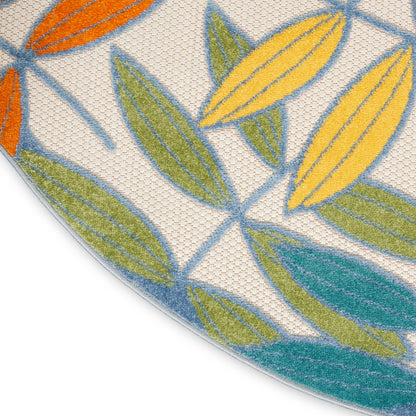 Round beige woven rug with bright leaf motif in orange, yellow, green and teal.