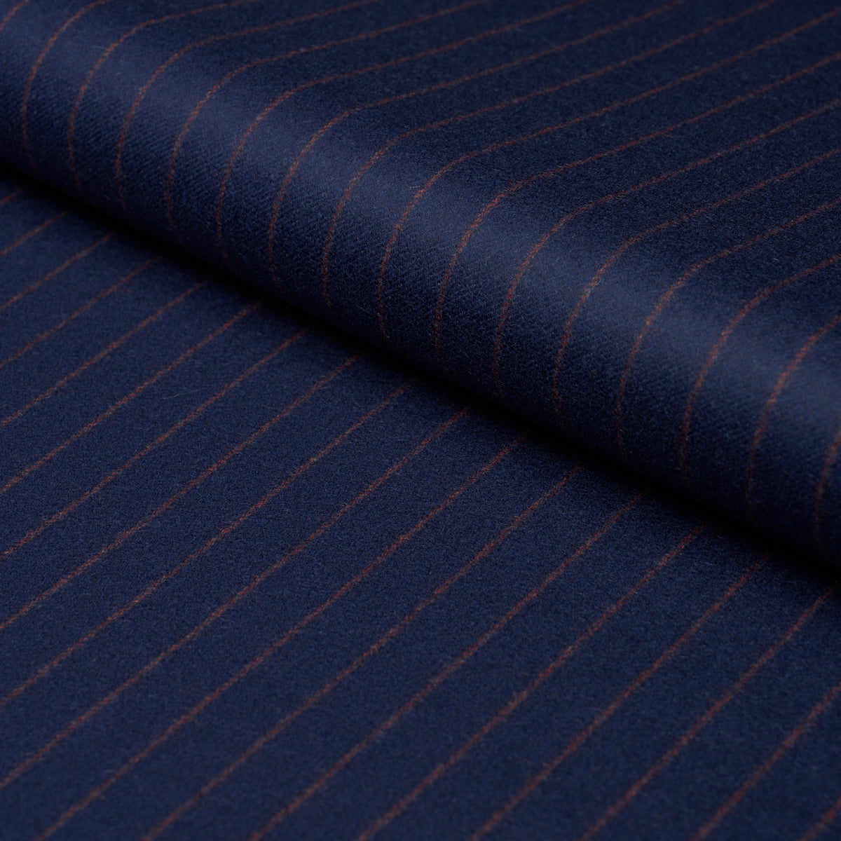 Navy blue pinstripe fabric with thin copper-brown stripes, rolled edge, suited for jackets and trousers.