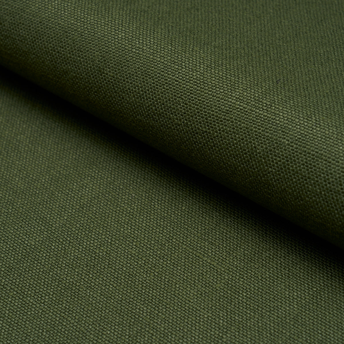 Olive green canvas fabric close-up with tight weave and folded edge.
