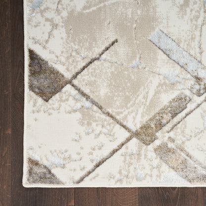 Neutral abstract geometric rug with cream, beige, gray and taupe shapes on dark wood floor; edge bound.