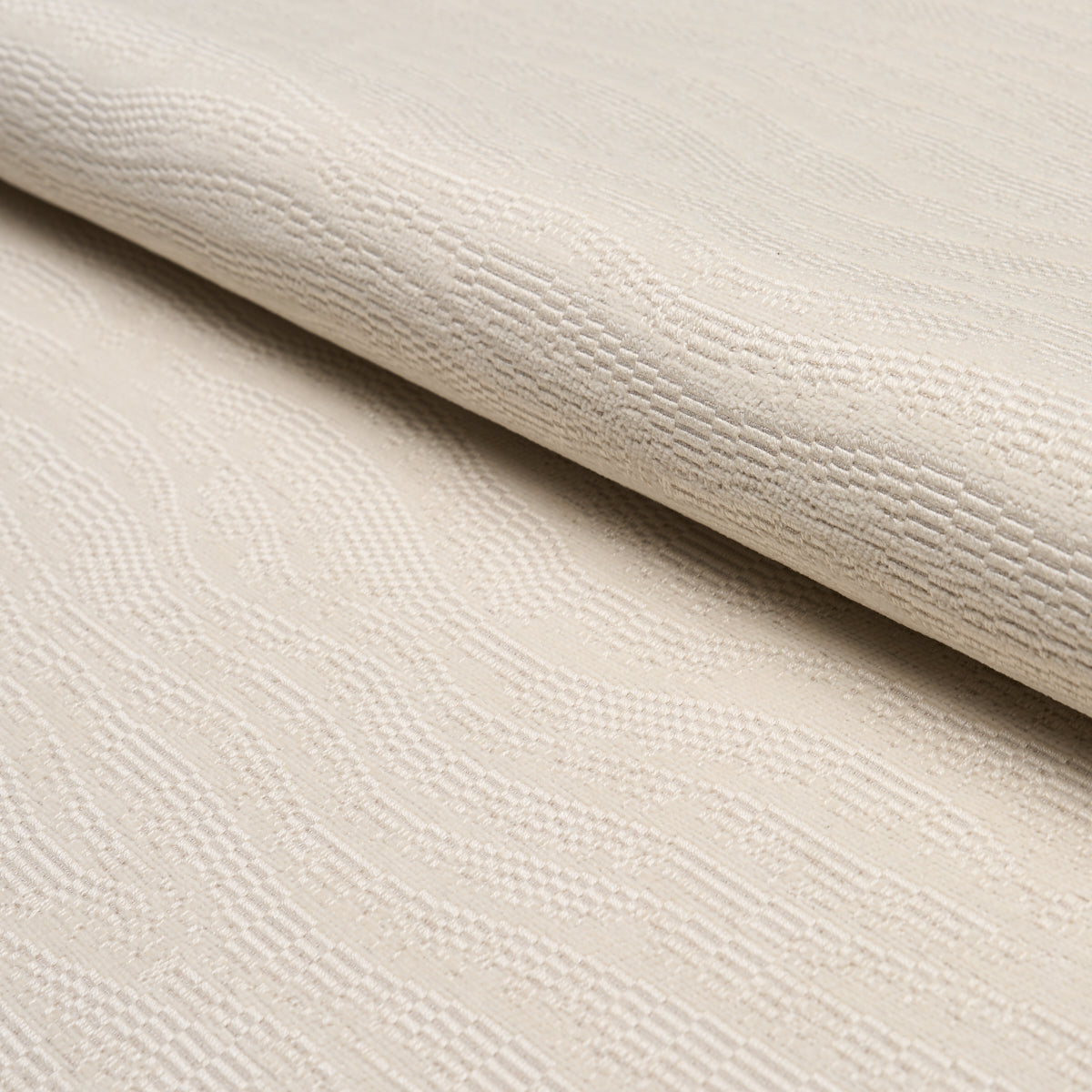 Beige jacquard fabric with subtle wave damask pattern, rolled edge, soft textile.