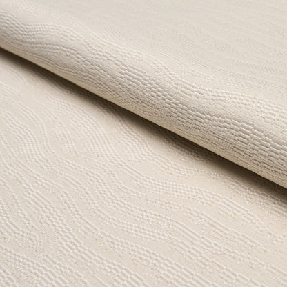 Beige jacquard fabric with subtle wave damask pattern, rolled edge, soft textile.