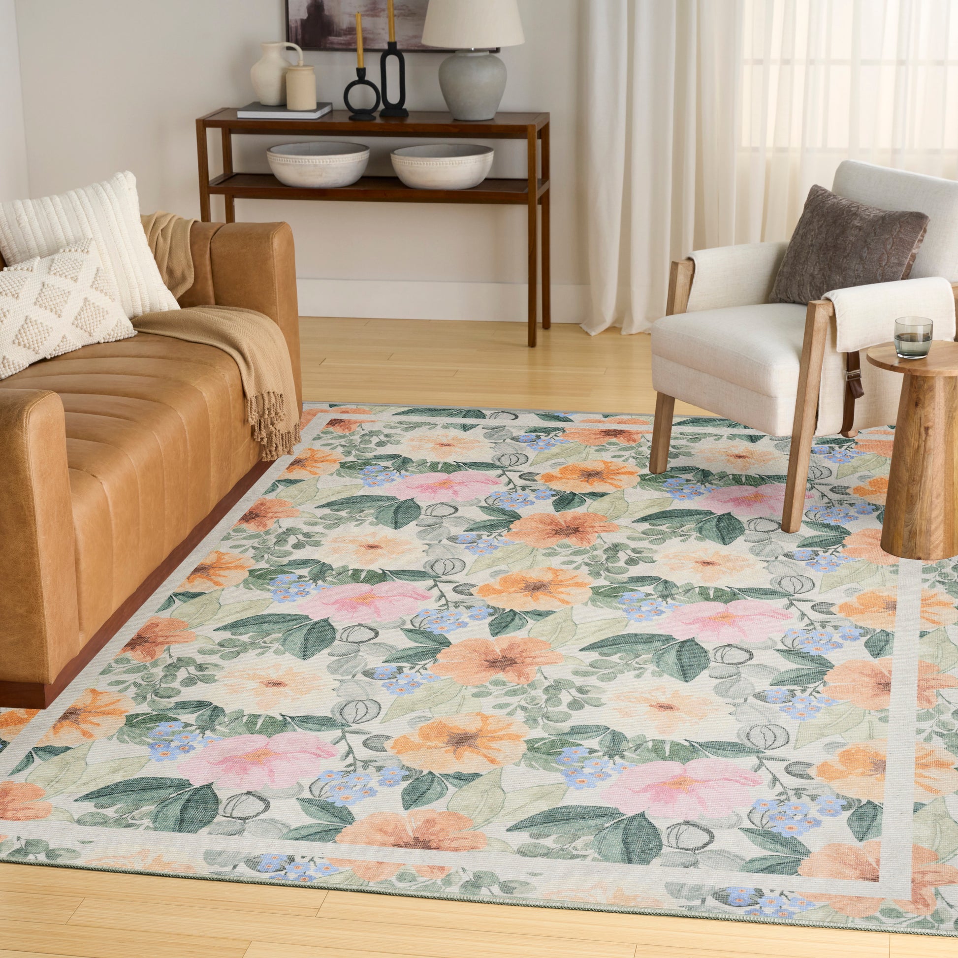 Pastel floral area rug with peach, pink, blue blooms and green leaves in a bright living room.