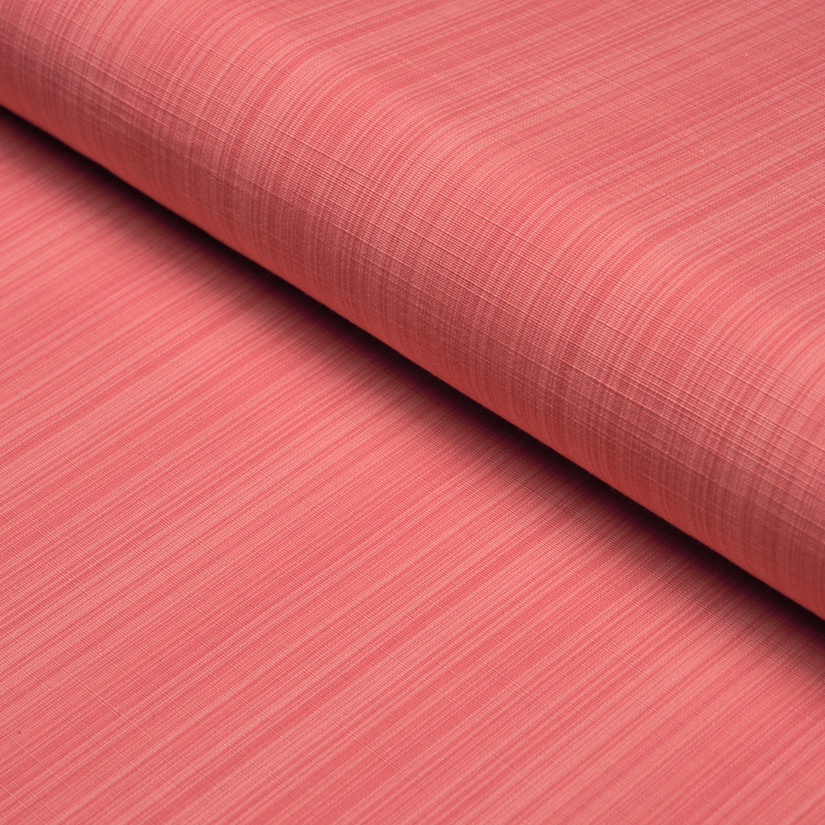 Coral woven fabric roll with a linen-like texture; drapable for sewing or upholstery.