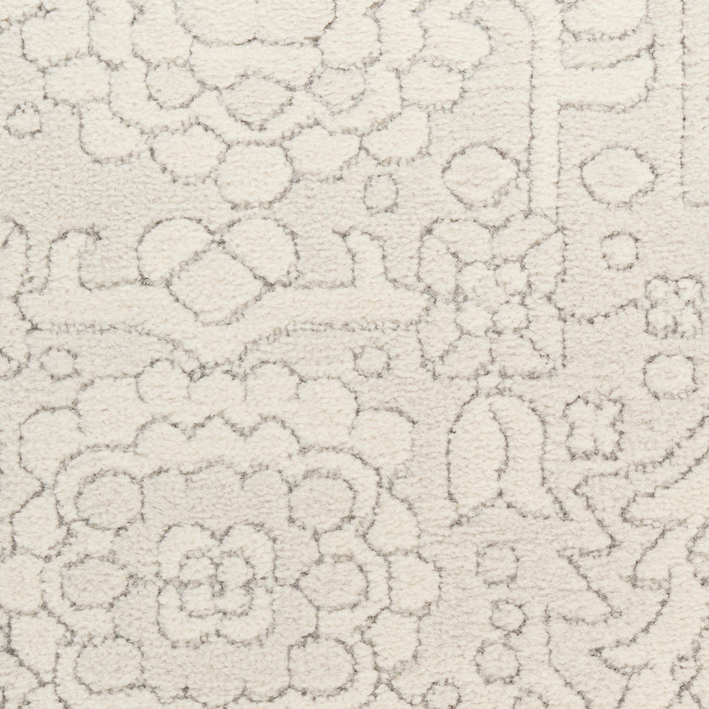 Cream textured rug with raised floral and geometric motifs in soft plush pile