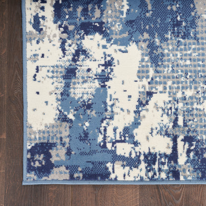 Abstract blue and white rug with irregular block pattern, modern geometric design, on wood floor.