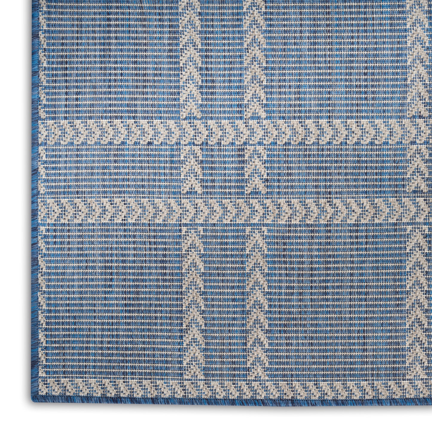 Blue woven area rug with ivory geometric chevrons and chain-border accents; modern tribal pattern, soft texture.